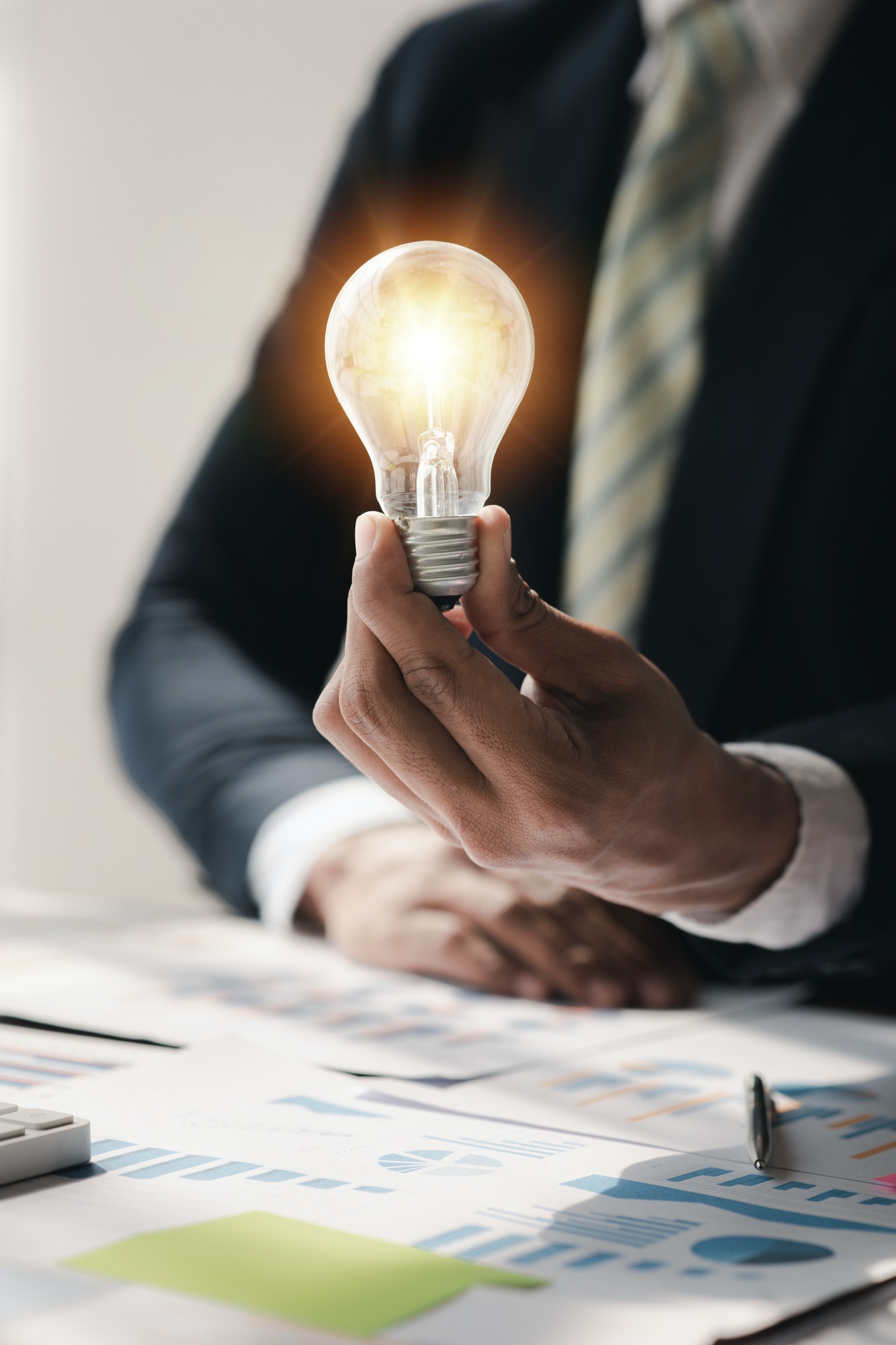 Standing man hold glowing light bulb, Creative new idea. Innovation, brainstorming, strategizing to